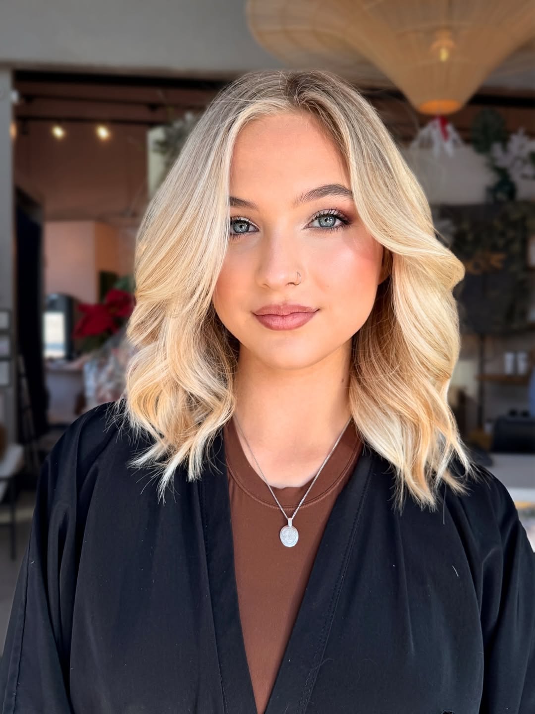 Close-up of a woman smiling, showcasing her soft summer blonde hair styled in loose waves, perfect for 2026. Her hair has natural highlights and lowlights, framing her face beautifully.