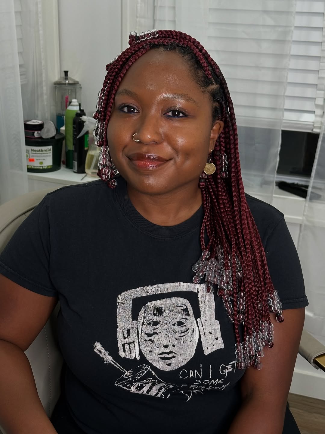 Close-up of a diverse woman with intricate summer braids ideas 2026, featuring subtle highlights and playful beaded accents for a bohemian vibe.