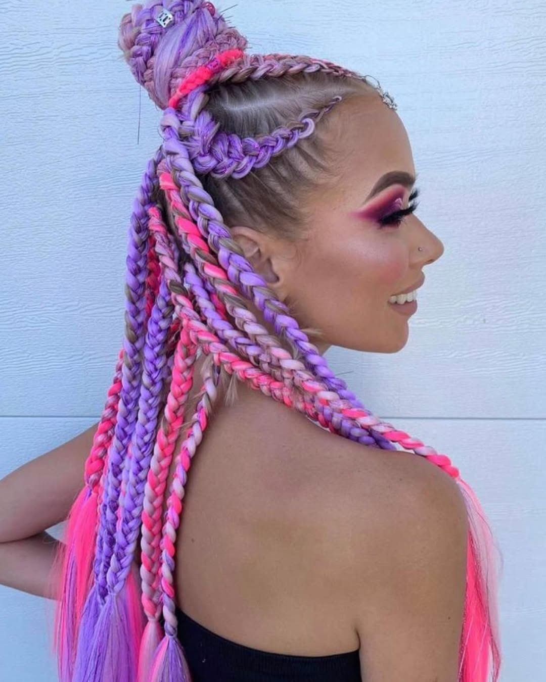Close-up of a woman with long, dark hair styled in intricate cornrows with beaded accents, showcasing elegant summer braids ideas. Perfect for a festival or beach vacation.