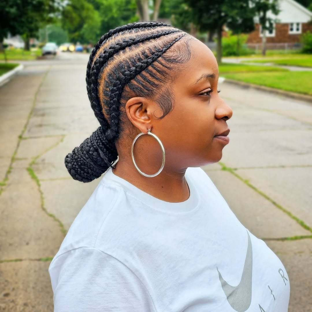 Close-up of a diverse woman with long, dark, intricately braided hair adorned with delicate gold cuffs, showcasing elegant summer braids ideas 2026. Perfect for a chic daytime look or evening event.