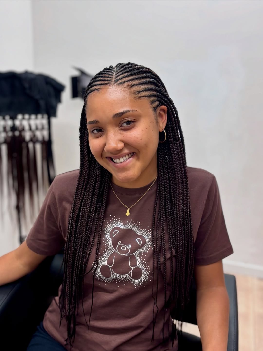 Close-up of a woman with beautiful, intricate summer braids ideas 2026, featuring sleek cornrows styled into a high bun, perfect for hot weather or active summer days.