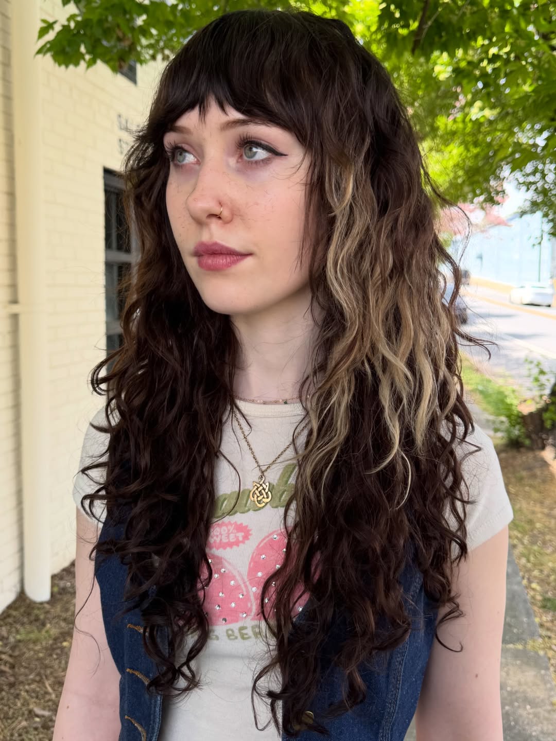 Close-up of a woman with vibrant, defined summer curly hairstyles 2026, showcasing healthy, bouncy curls in a natural brown shade. Perfect for a casual day out.
