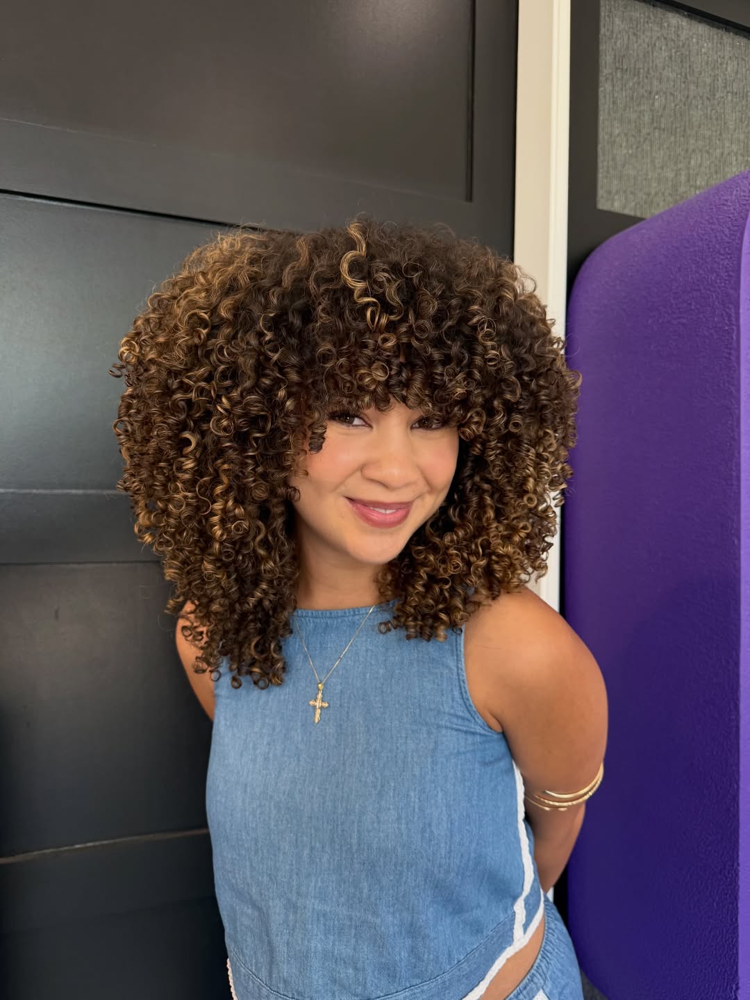 A beautiful woman with bouncy, radiant summer curly hairstyles 2026, ideal for a sunny outdoor occasion.