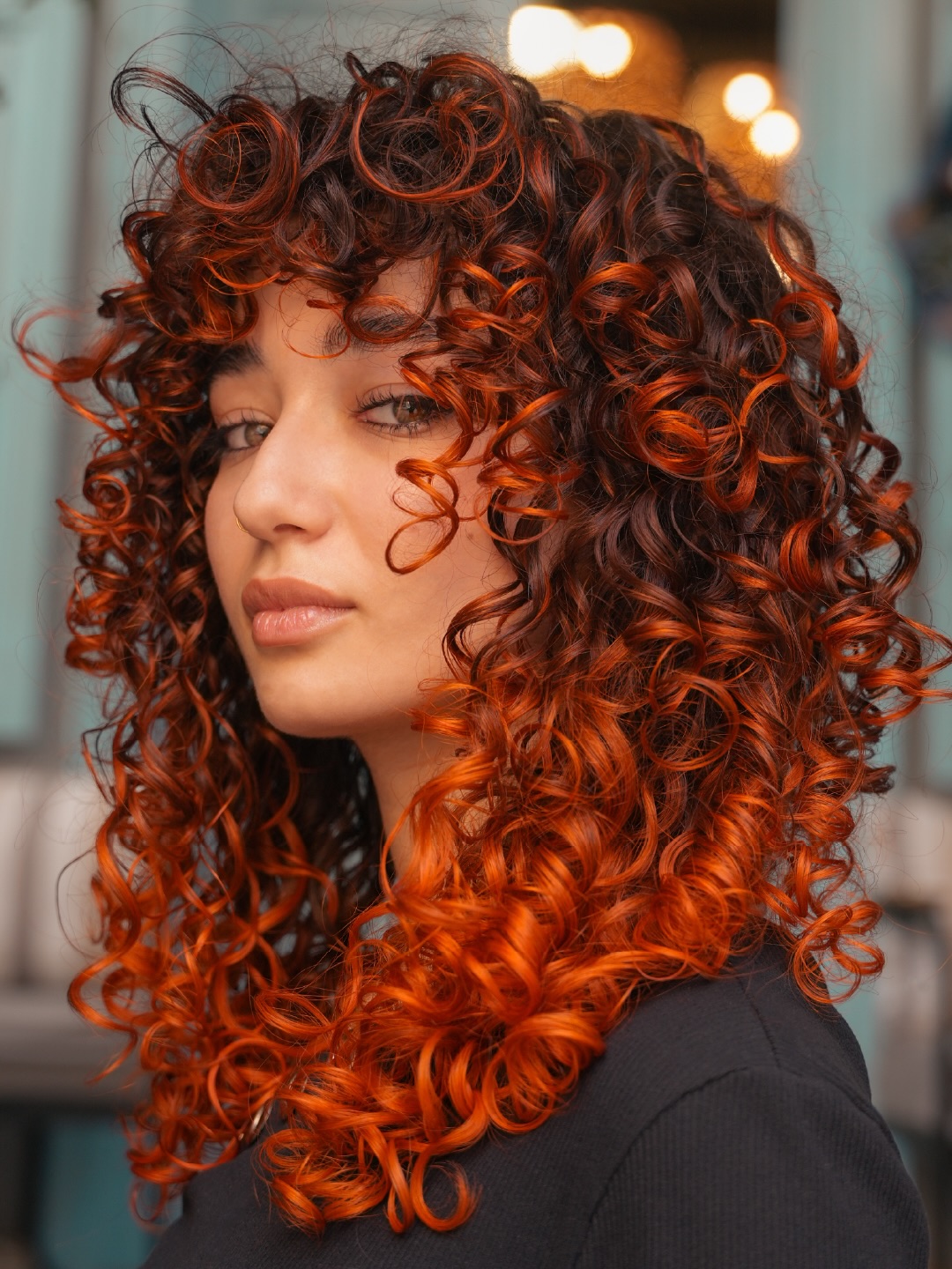 Beautiful woman with bouncy summer curly hairstyles 2026, featuring defined, voluminous curls cascading over her shoulders, perfect for a casual sunny day look.
