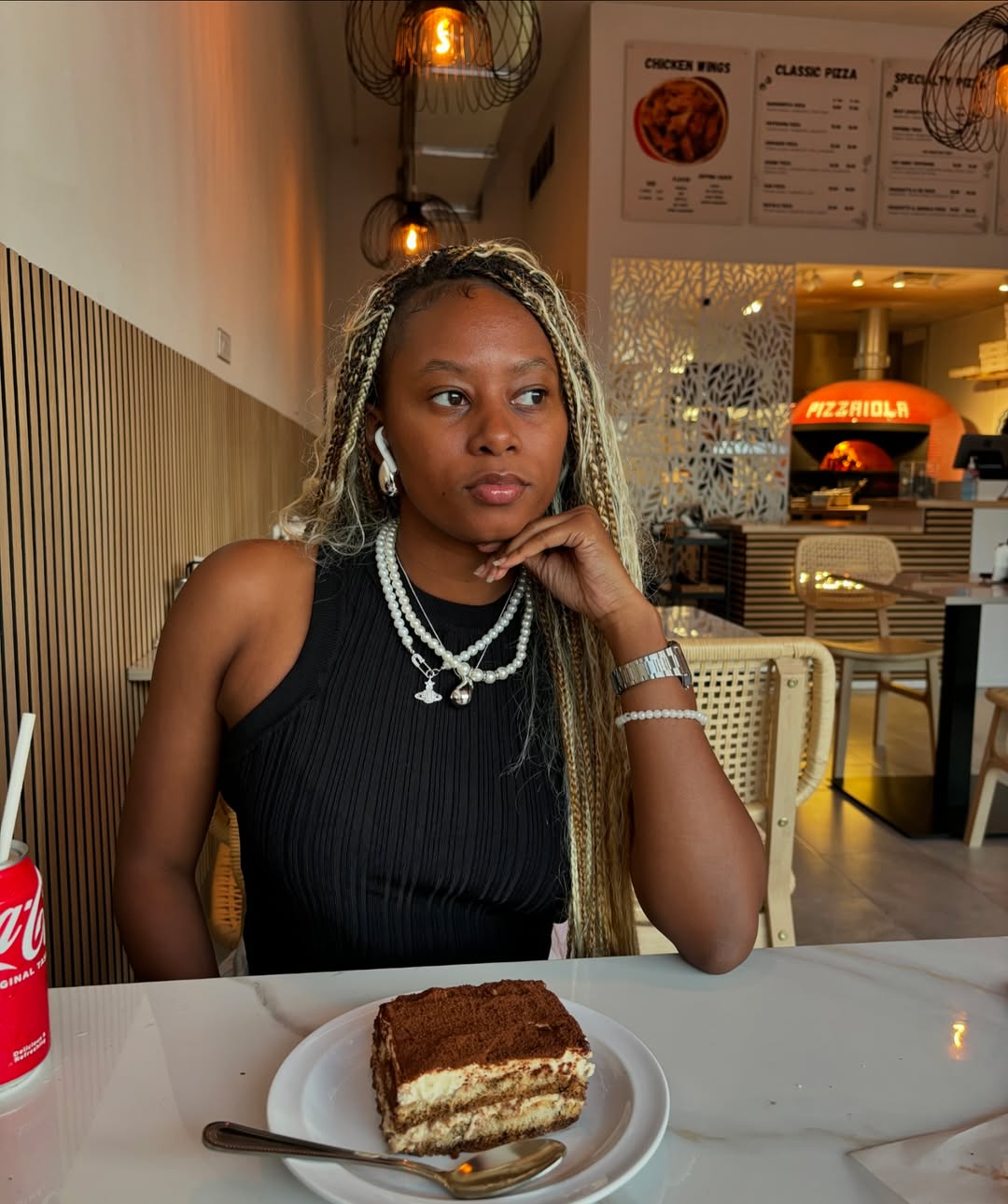 Close-up of a Black woman with natural texture hair styled in trendy summer hairstyles for black women 2026, showcasing a chic updo perfect for day-to-night events. Her hair features highlights and braided details.