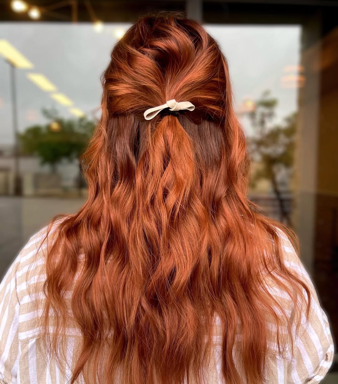 Woman showcasing a 'true summer hair color 2026' trend; soft, cool-toned blonde hair paired with a casual white t-shirt and minimal makeup, perfect for everyday wear.