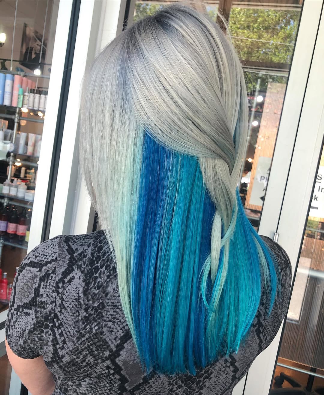 Close-up of a woman with radiant, cool-toned dark blonde hair, perfect for true summer hair color 2026. Her hair is styled in soft waves, accentuating her light eyes and creating a harmonious, natural glow.