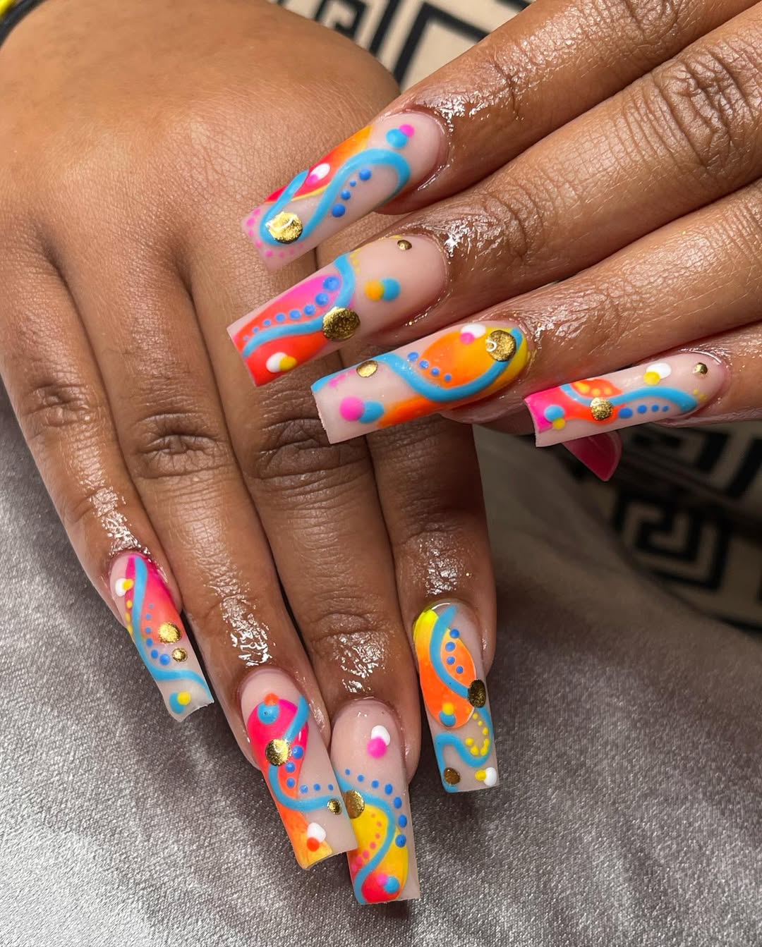 Vibrant Abstract Squoval Nails with Gold Embellishments