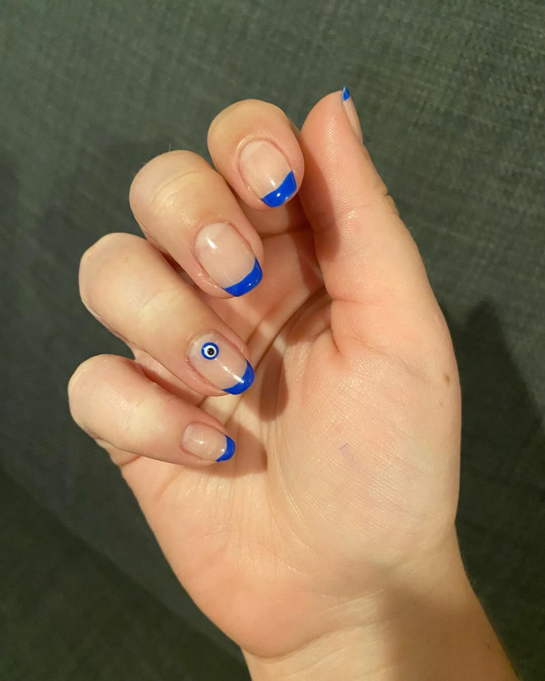 Vibrant Blue French Tips with Evil Eye Accent