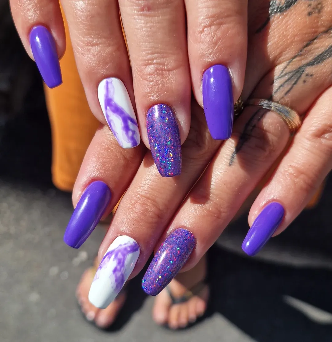 Vibrant Purple Nails with Marble and Glitter Accents