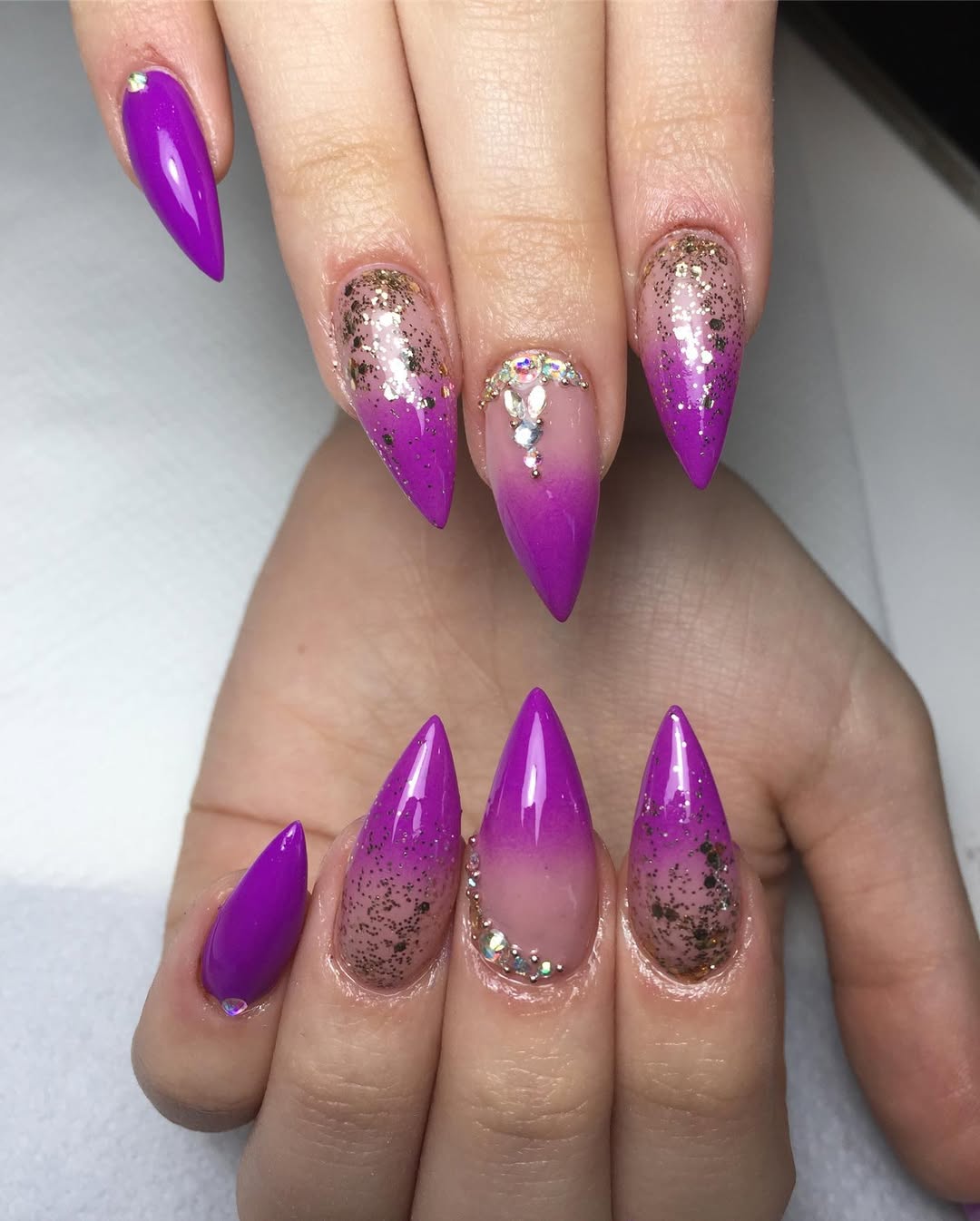 Vibrant Purple Ombre Stiletto Nails With Gold Glitter And Rhinestones