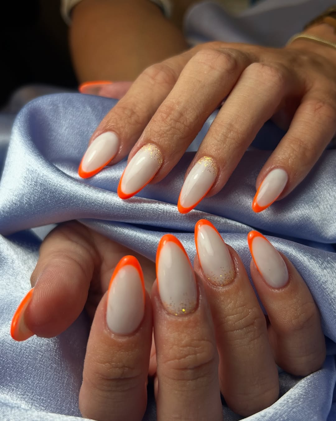 Bright Orange Glossy Almond French Tips with Glitter Detail