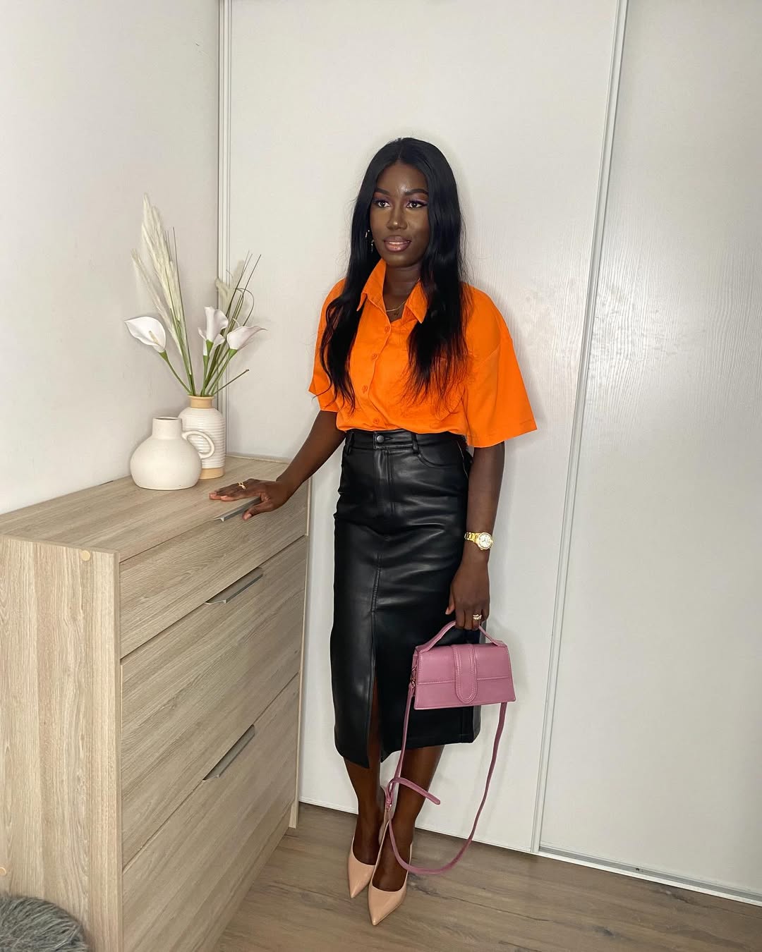 Chic Contrast: Orange Top Meets Black Leather Midi