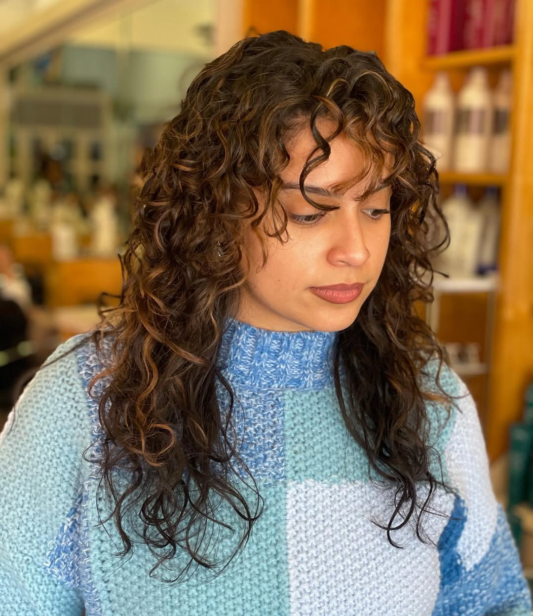 Curly Shag With Caramel Highlights And Textured Bangs