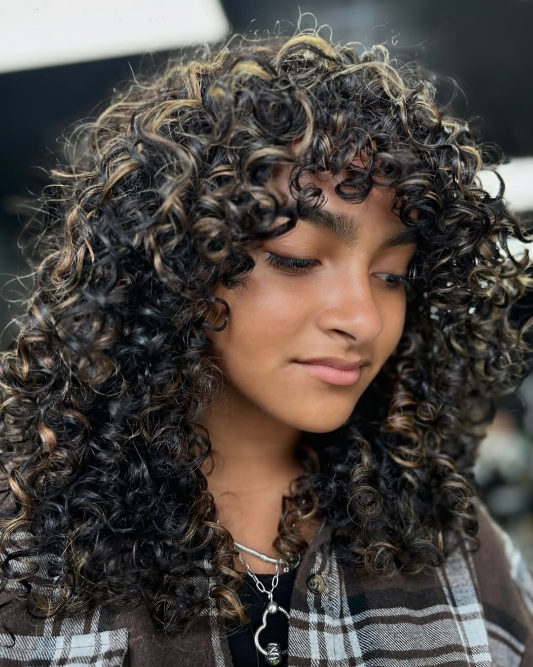 Defined Curly Mid-Length Cut With Wispy Bangs