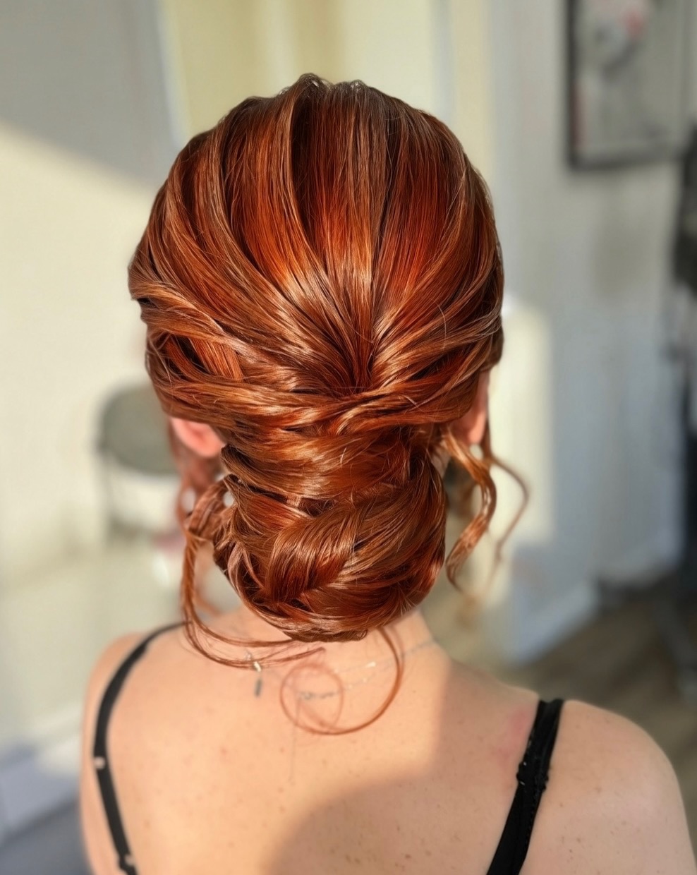 Elegant Textured Auburn Low Bun With Tendrils