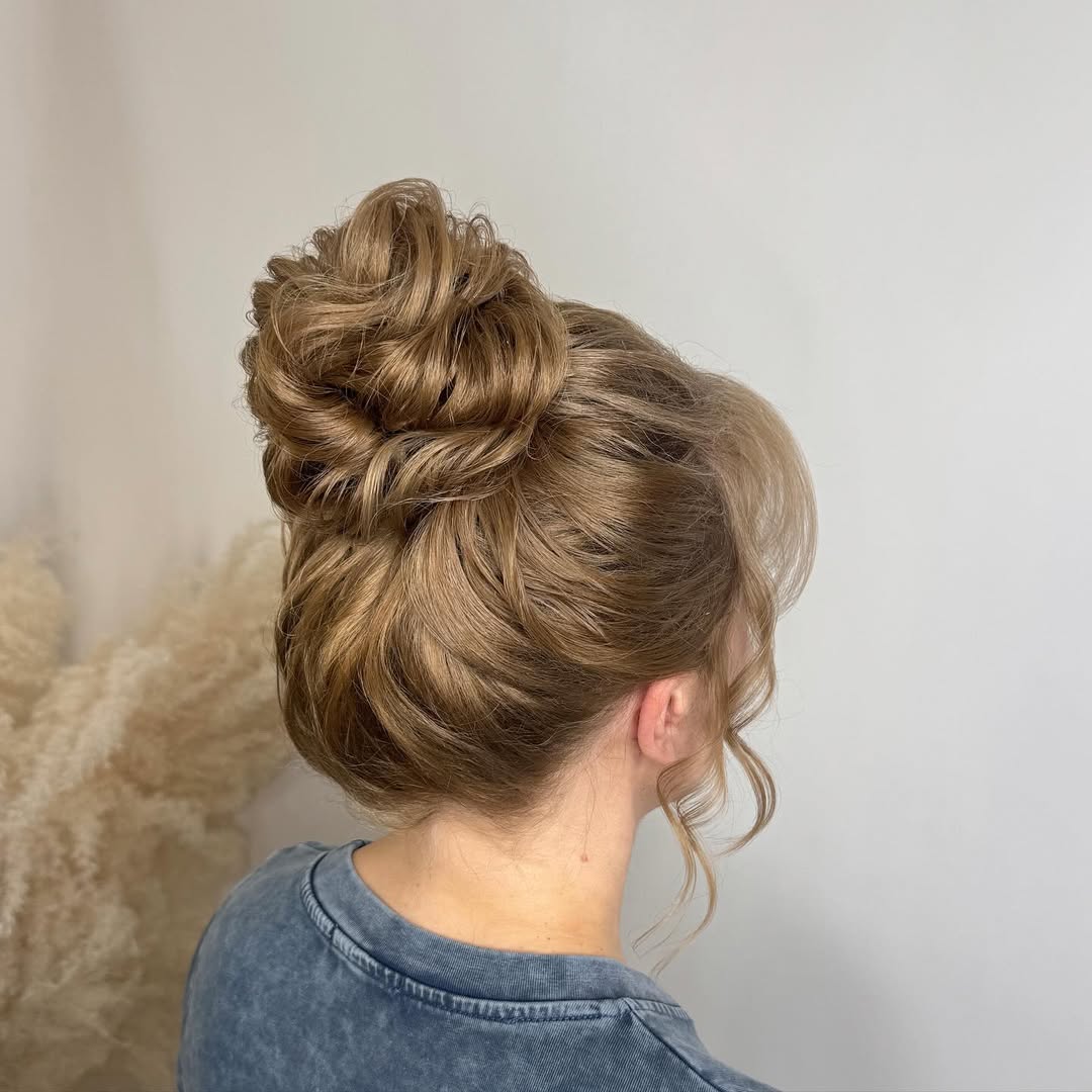 Elegant Wavy High Bun With Face-Framing Tendrils