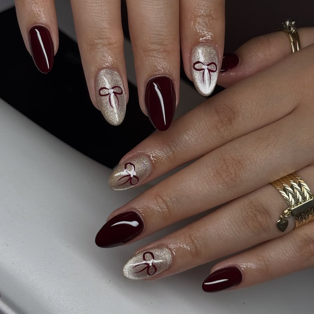 Glossy Burgundy And Shimmer Gold Bow Almond Nails
