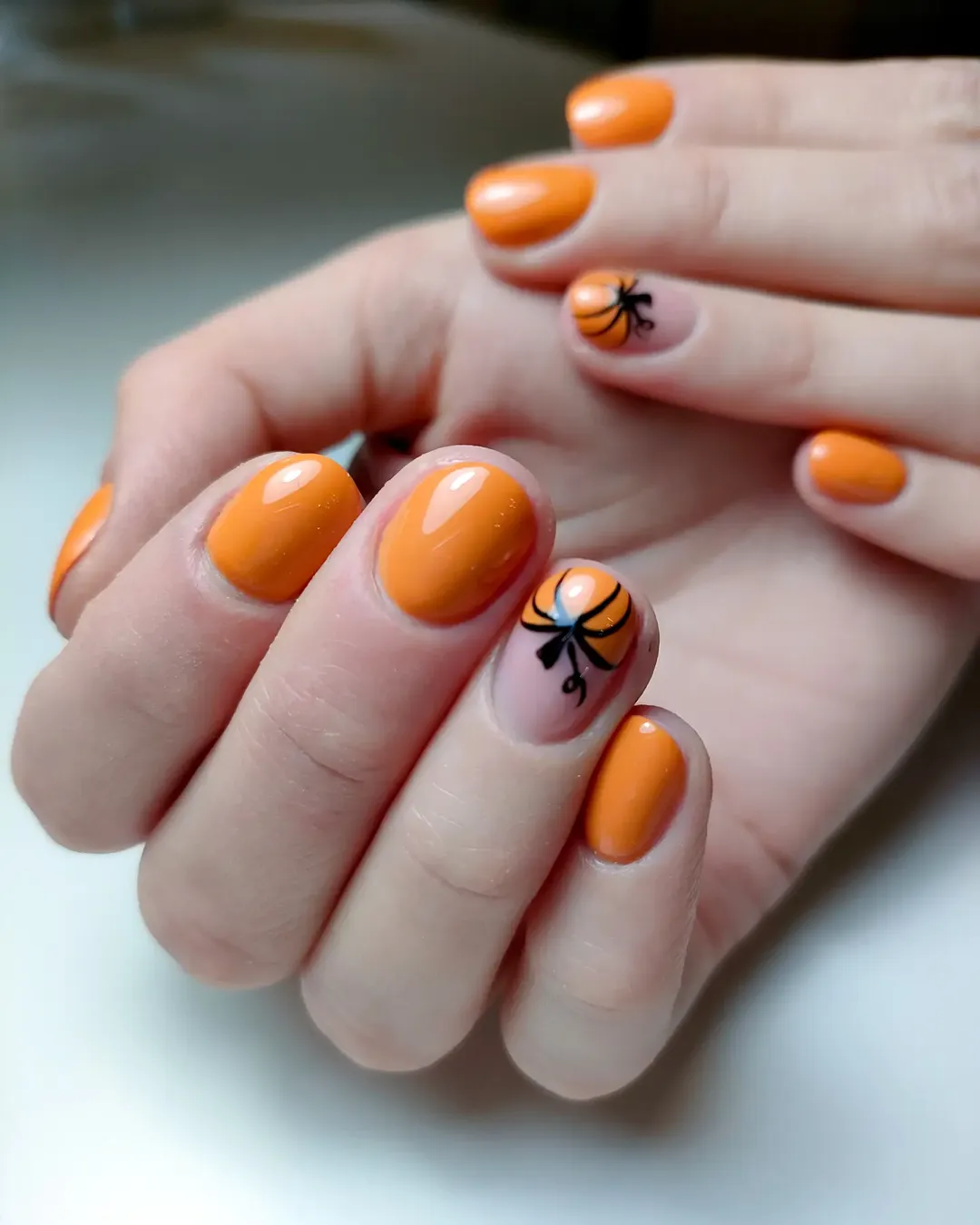 Glossy Orange Pumpkin Nail Art with Black Bow