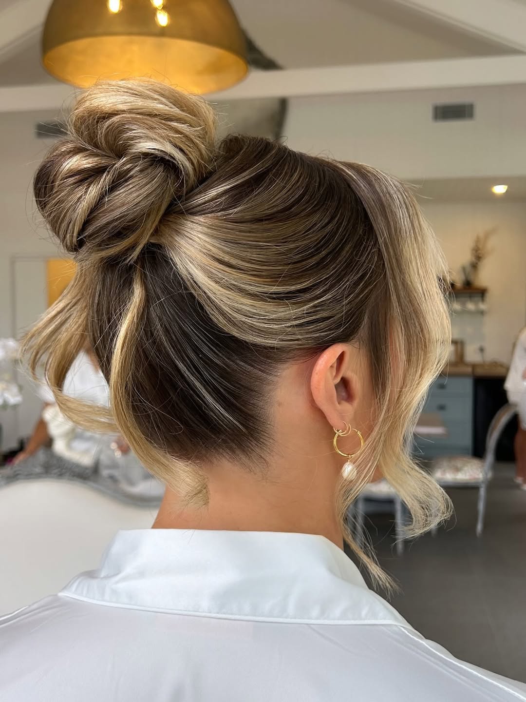 Messy High Bun With Face-Framing Layers