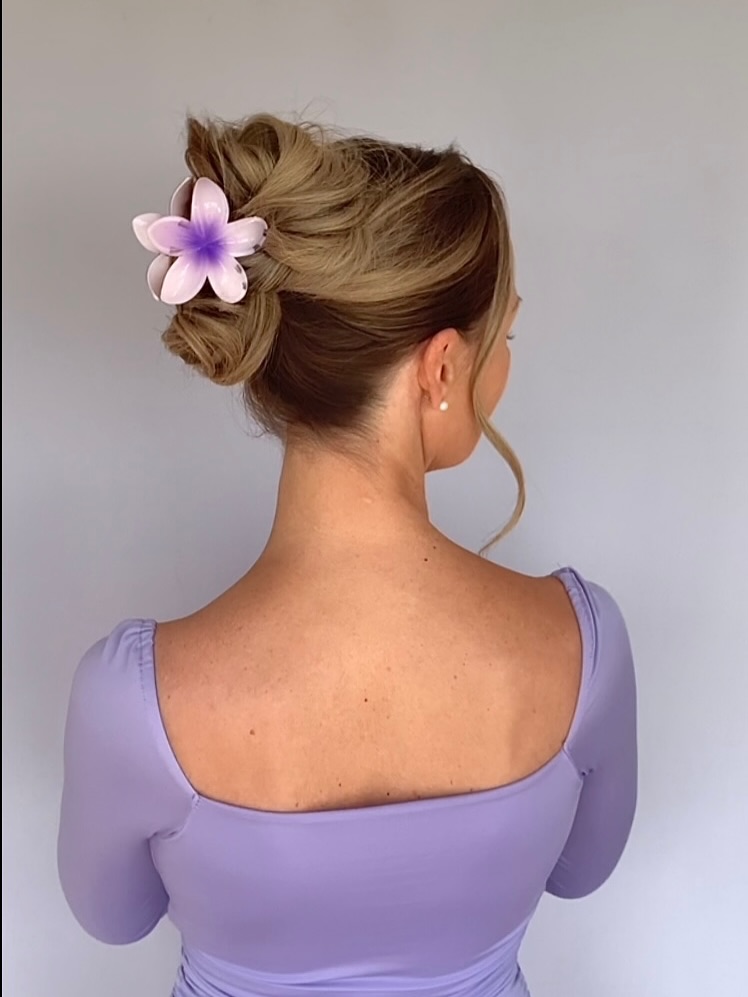 Relaxed Low Bun With Wispy Face Frames And Flower Clip