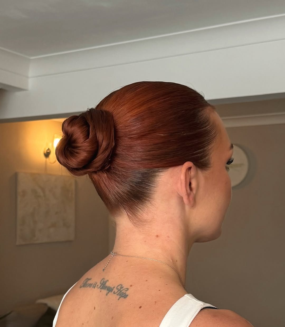 Sleek Auburn Low Bun With Glossy Finish