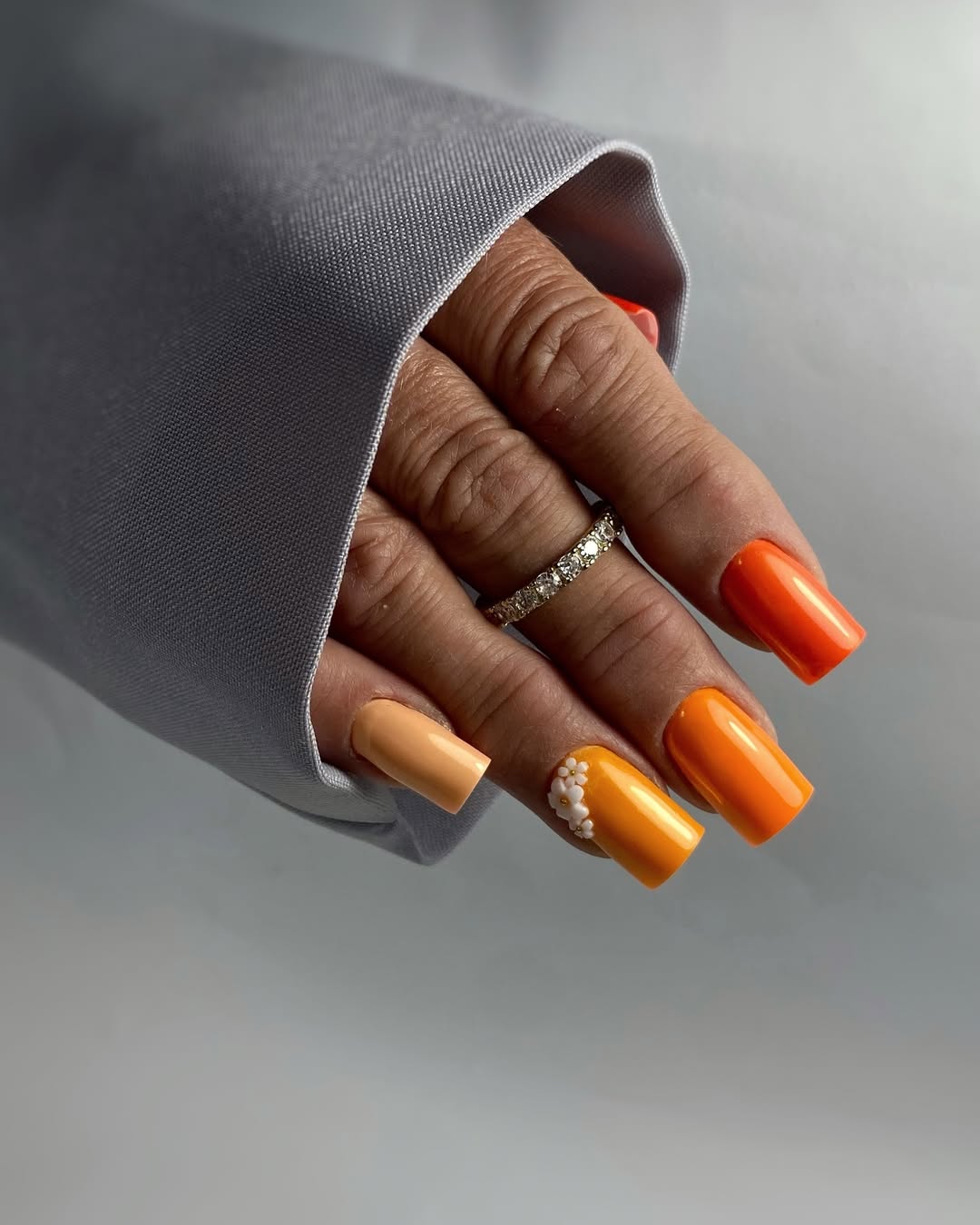 Vibrant Orange And Peach Square Nails With Floral Accents