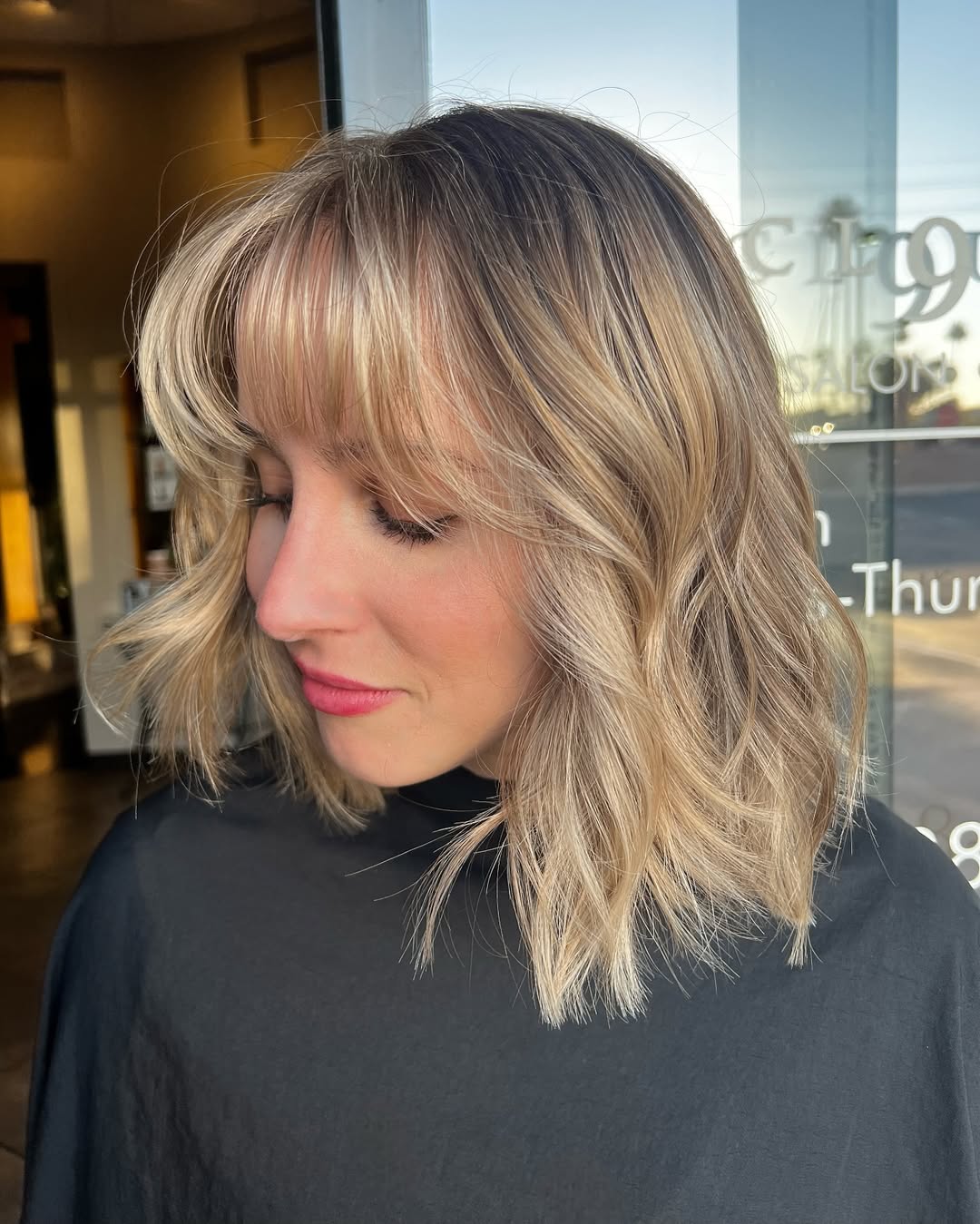 Wavy Blonde Bob With Wispy Bangs And Shadow Root