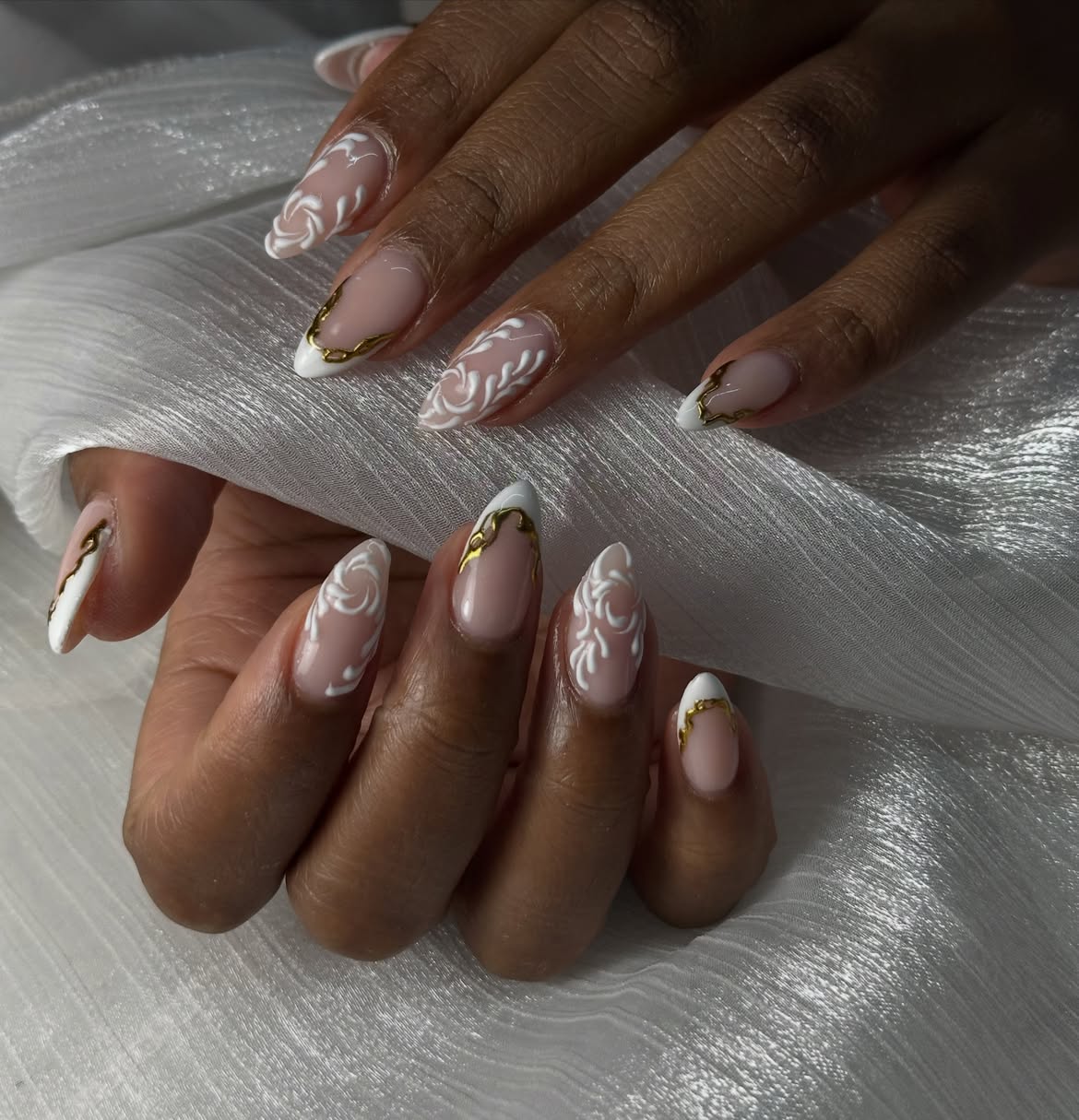 Elegant White Swirl Almond Nails with Gold Accents