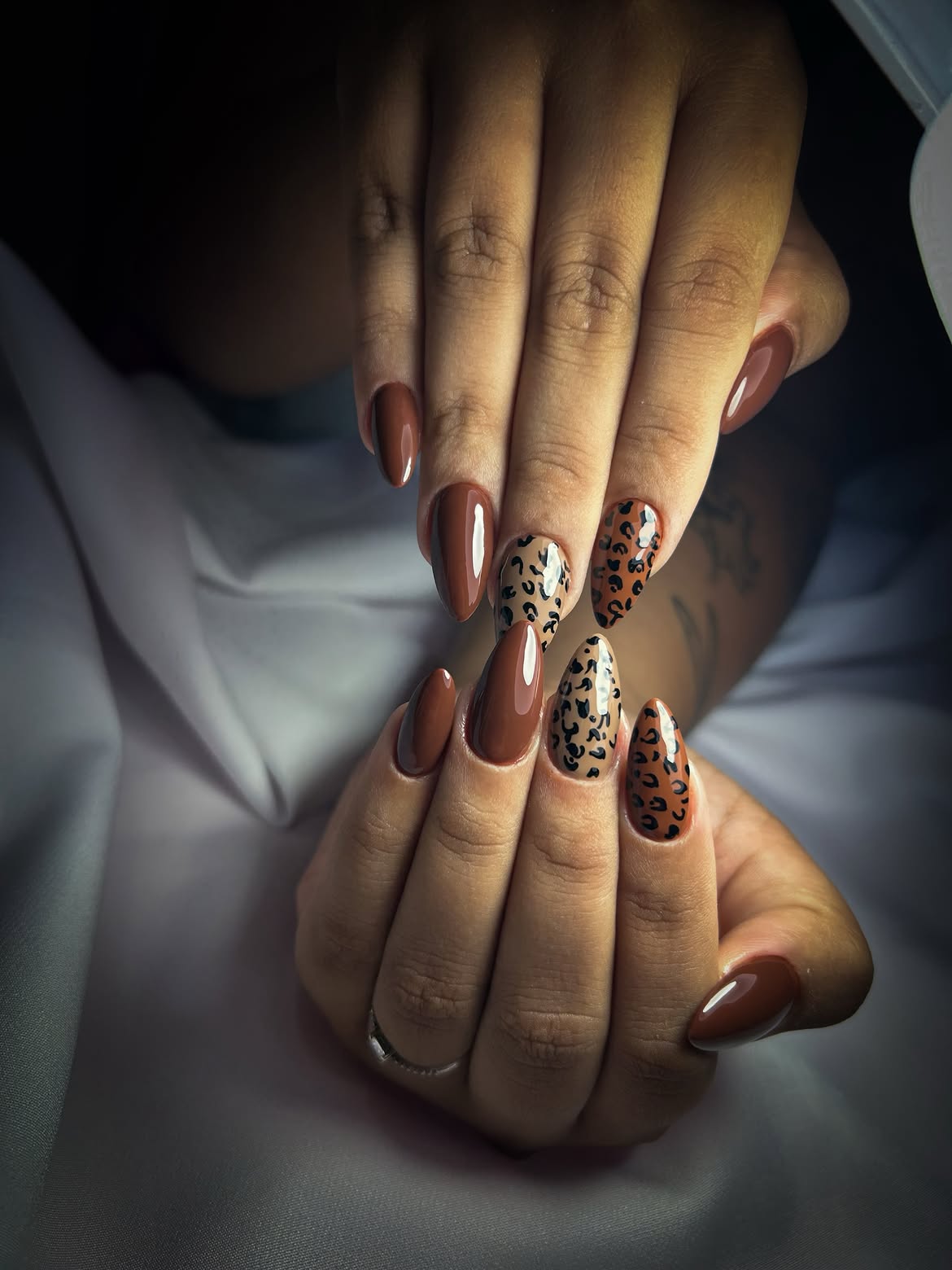 Glossy Rich Brown Almond Nails with Leopard Print Accents