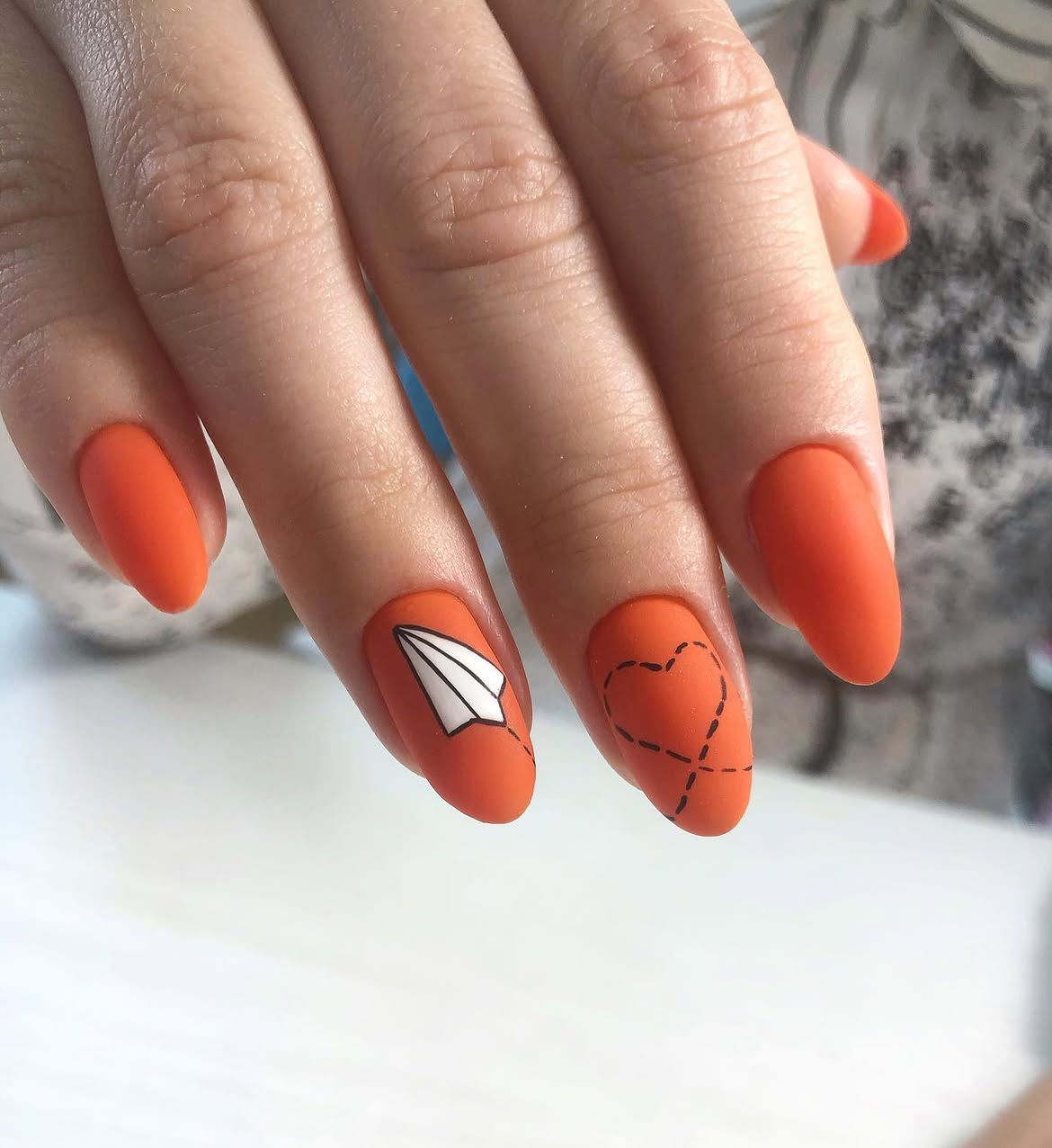 Matte Orange Almond Nails with Paper Plane Art