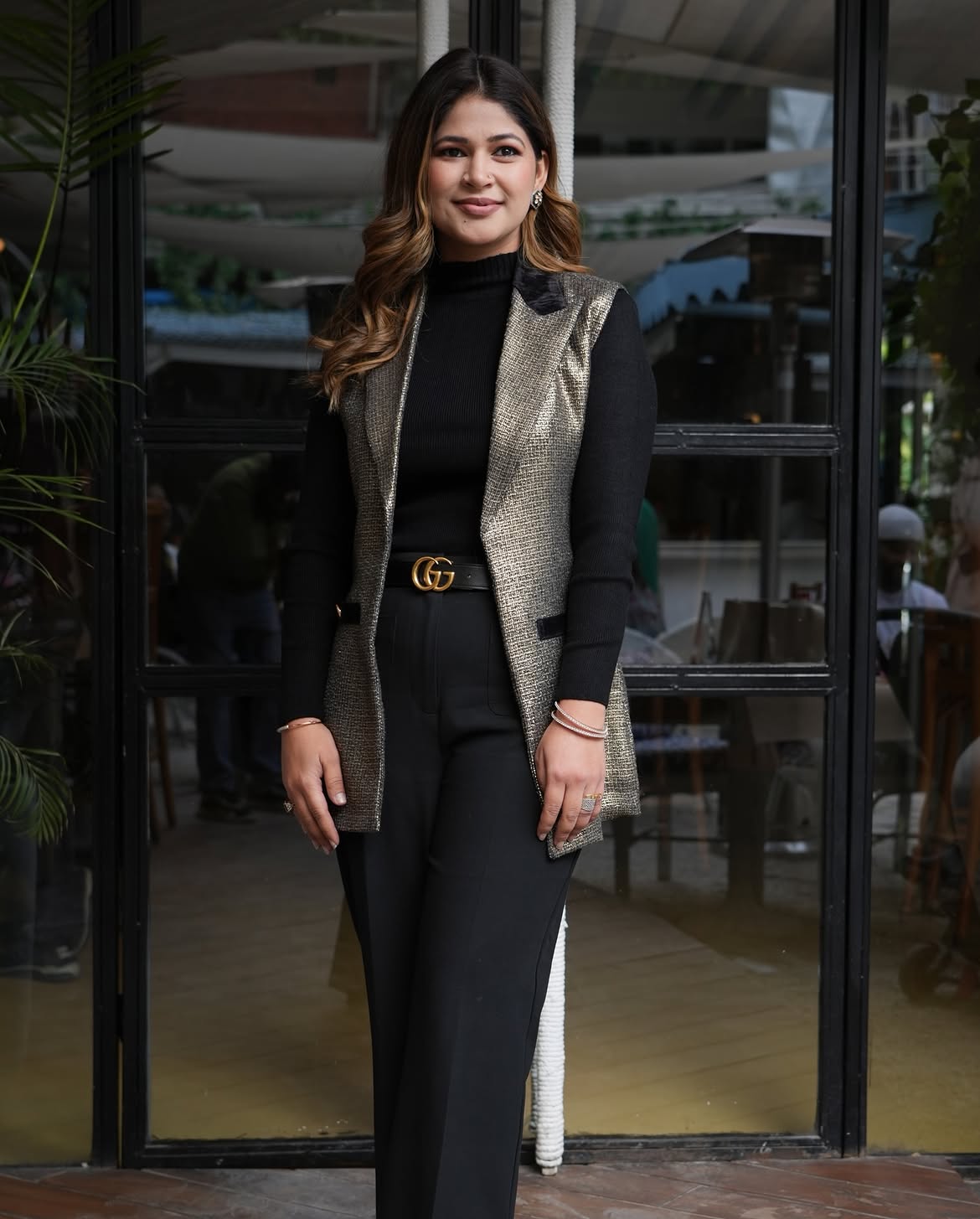 Metallic Textured Vest Over Black Turtleneck And Trousers