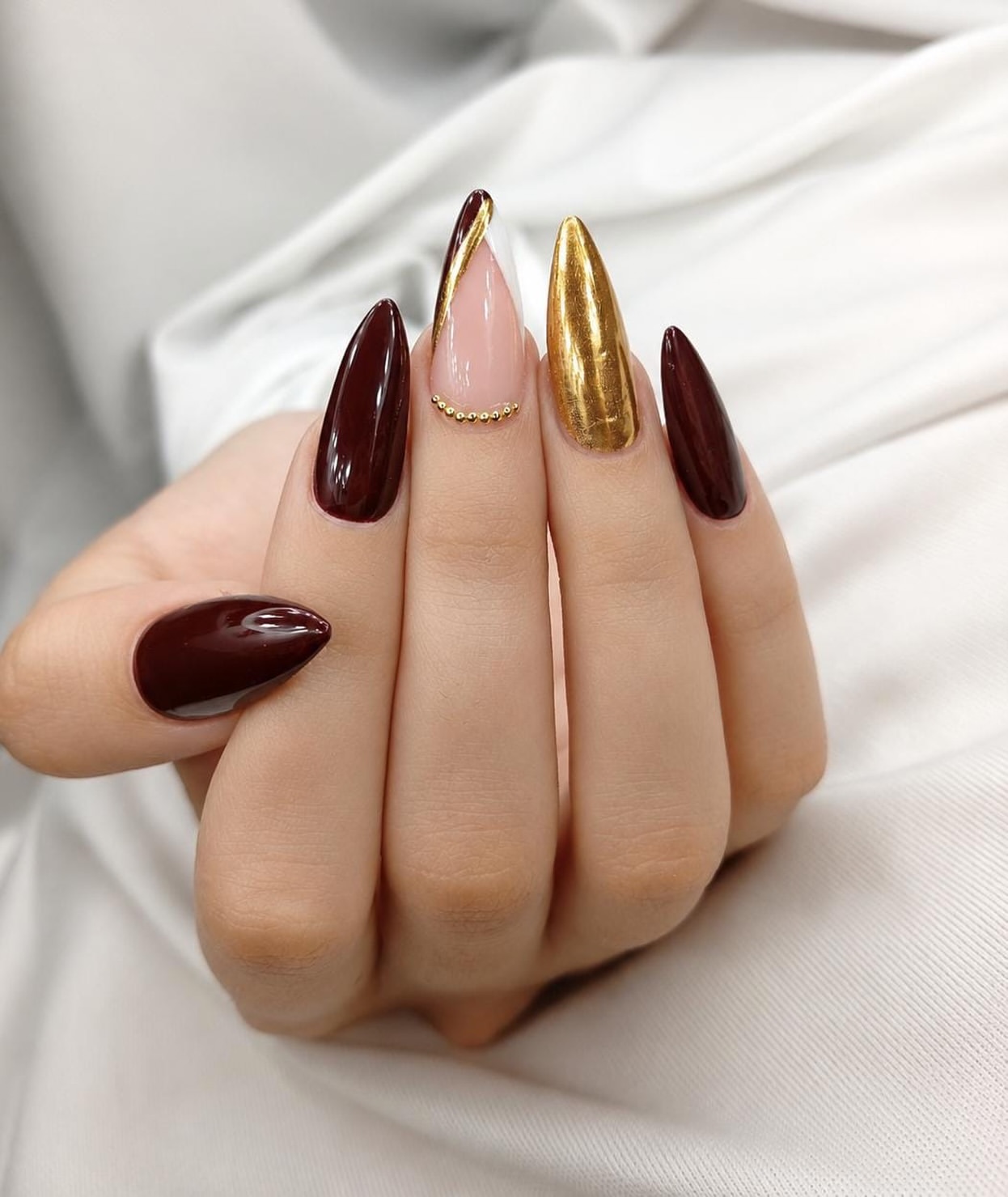 Rich Burgundy And Gold Chrome Stiletto Nails