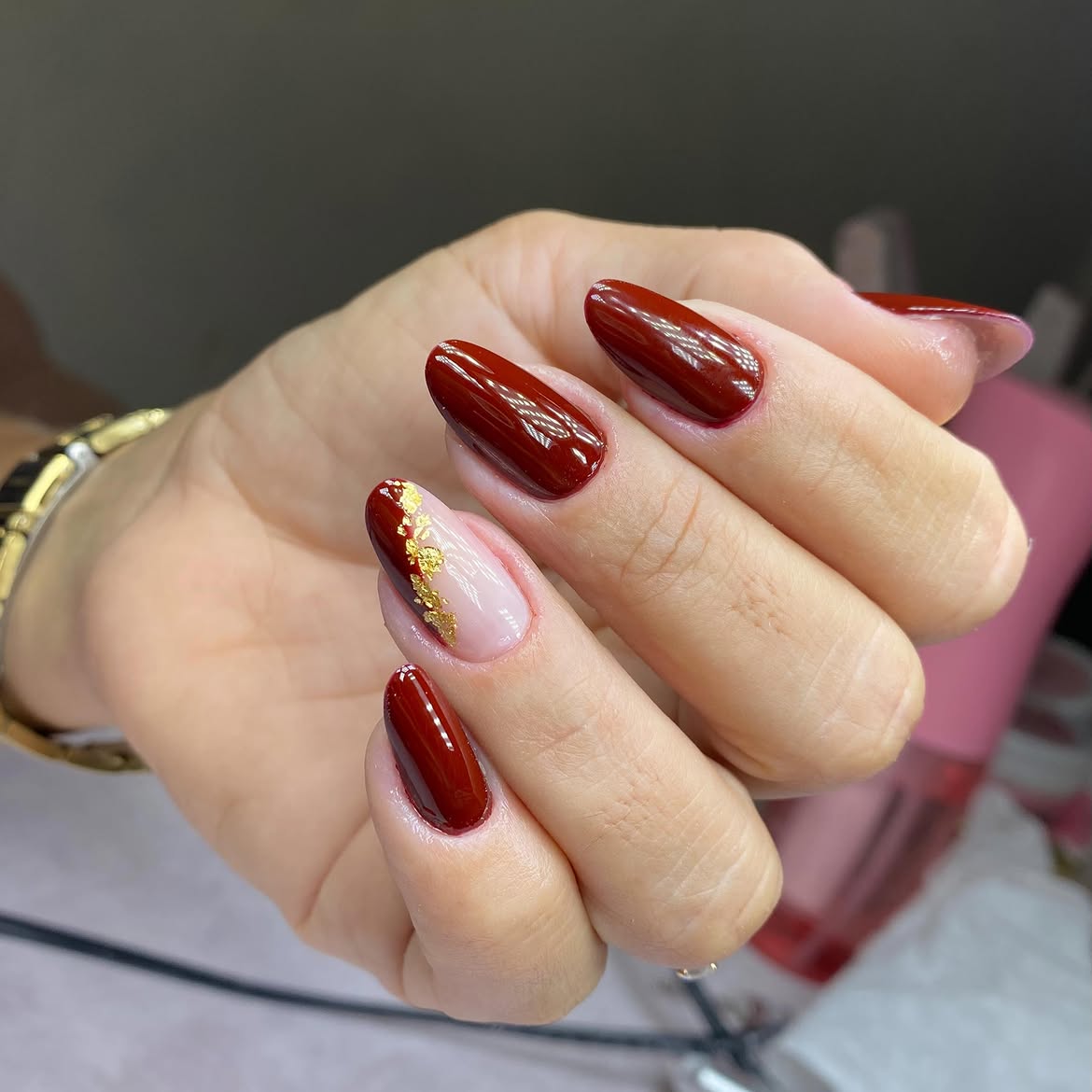 Rich Burgundy Oval Nails with Gold Flake Accent