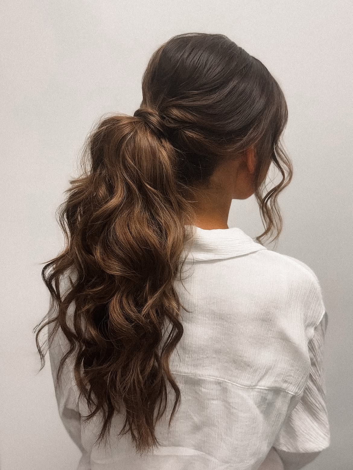 Voluminous Wavy High Ponytail With Wrapped Accent