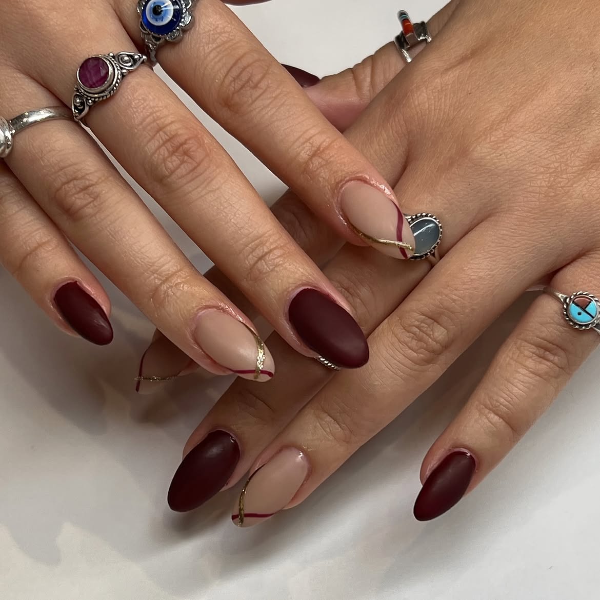Deep Burgundy and Nude Matte Almond Nails with Gold Lines