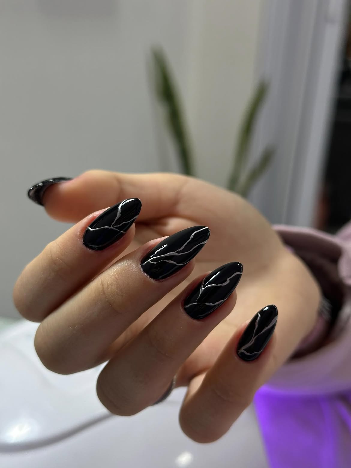Glossy Black Almond Nails with Silver Swirls