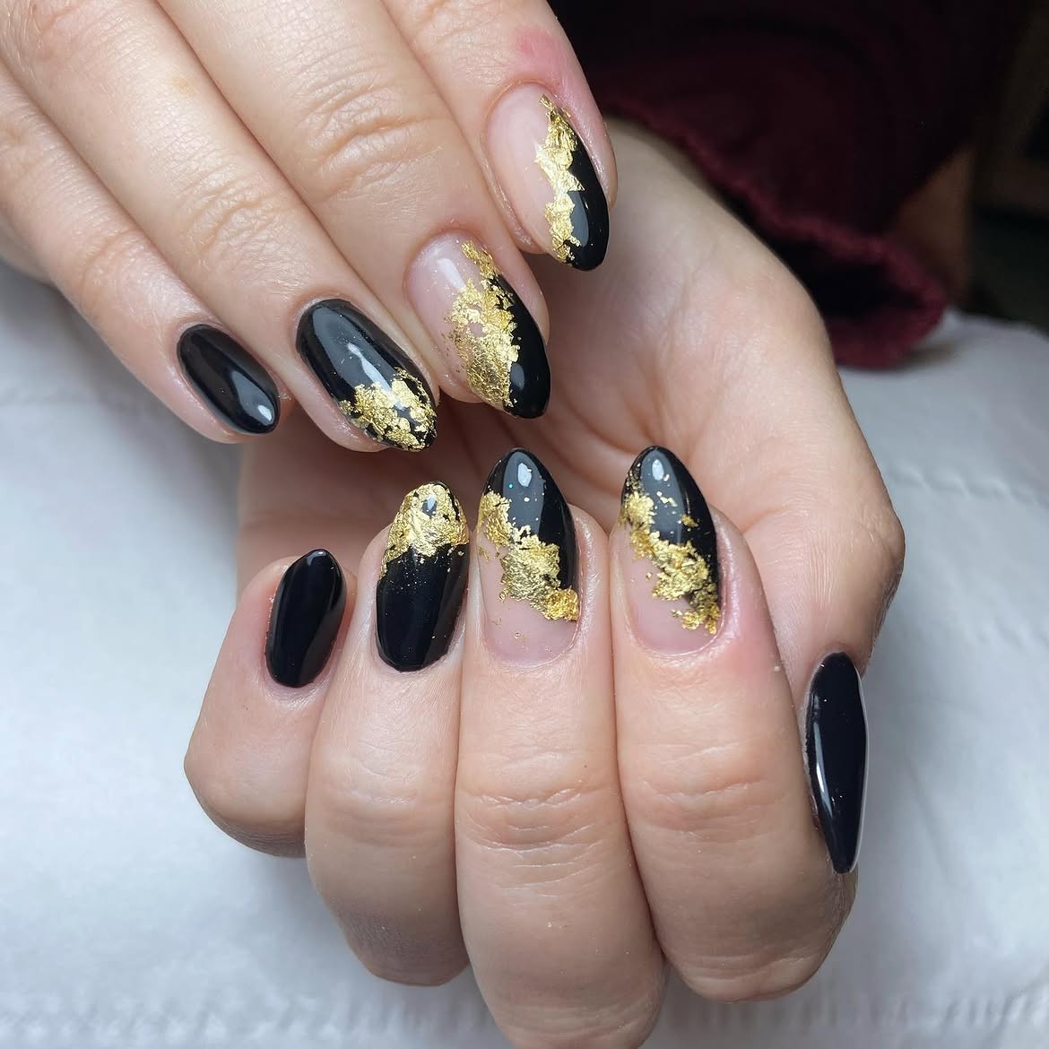 Glossy Black Oval Nails with Gold Foil Accents