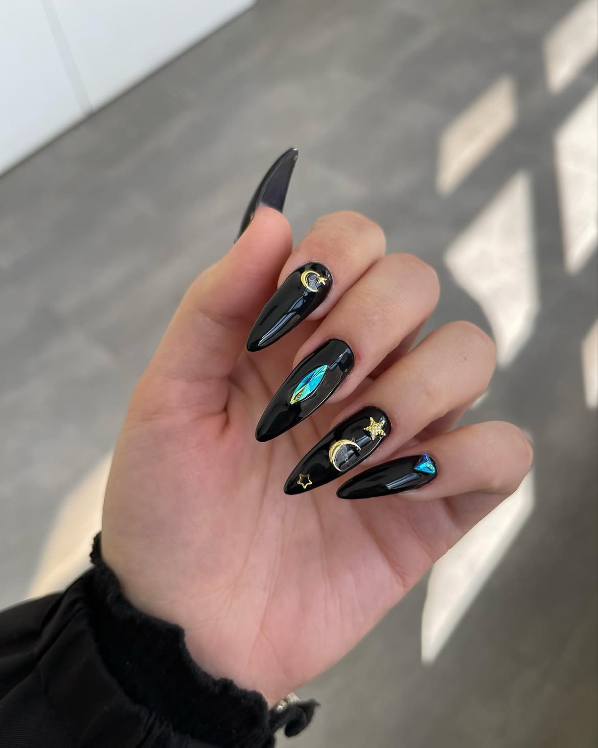 Glossy Black Stiletto Nails with Celestial Charms