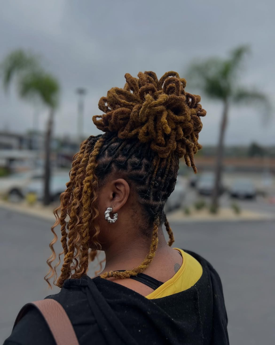 Honey Blonde Loc Bun With Curly Tendrils