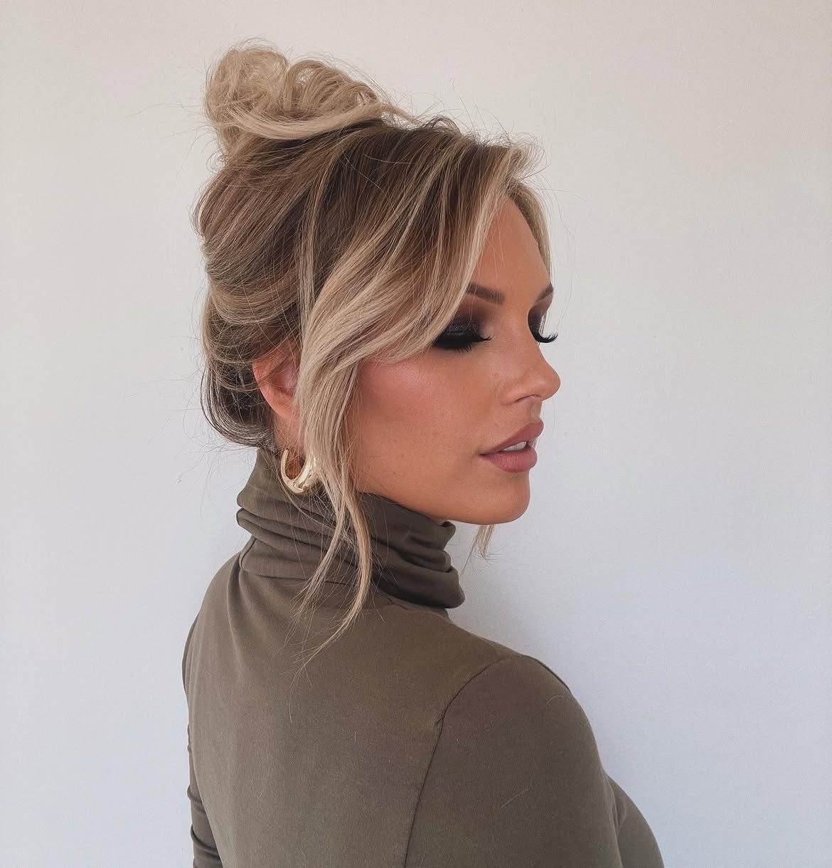 Messy High Bun With Wispy Face Framing Pieces