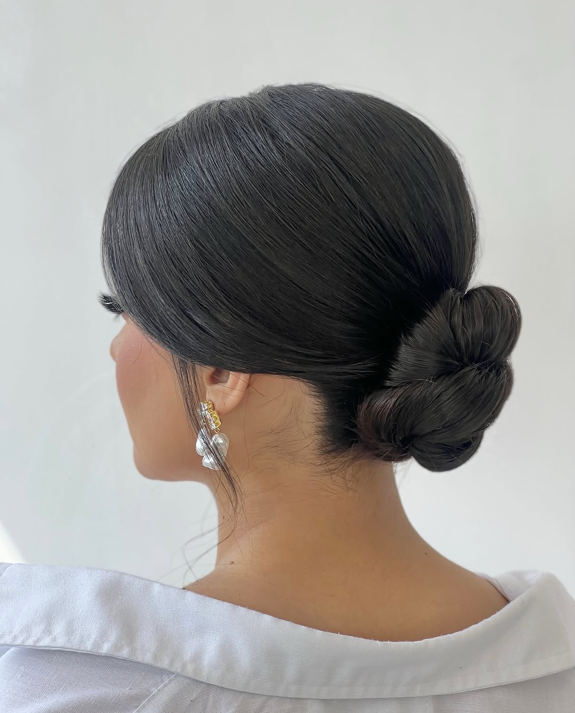 Polished Low Chignon With Face Framing Tendrils