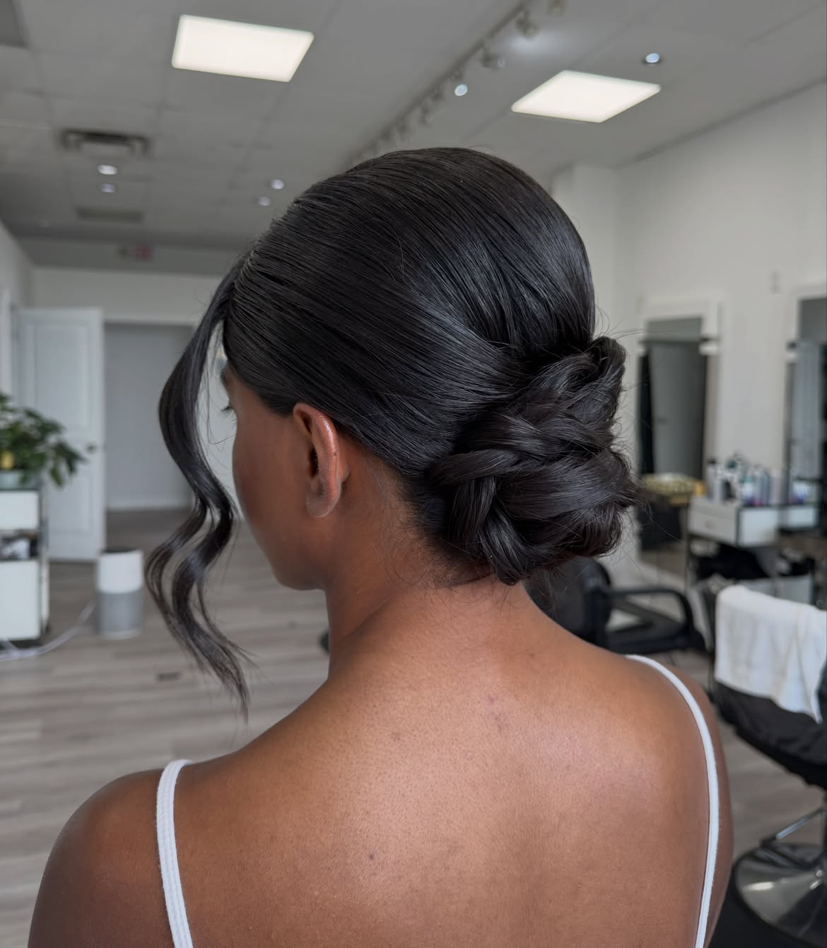 Sleek Low Braided Bun With Face Framing Waves