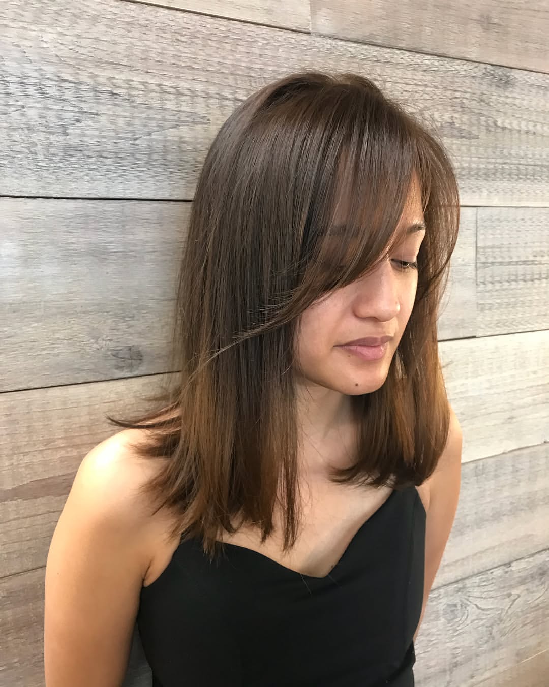 Sophisticated Side Swept Bangs On Medium Length Brunette