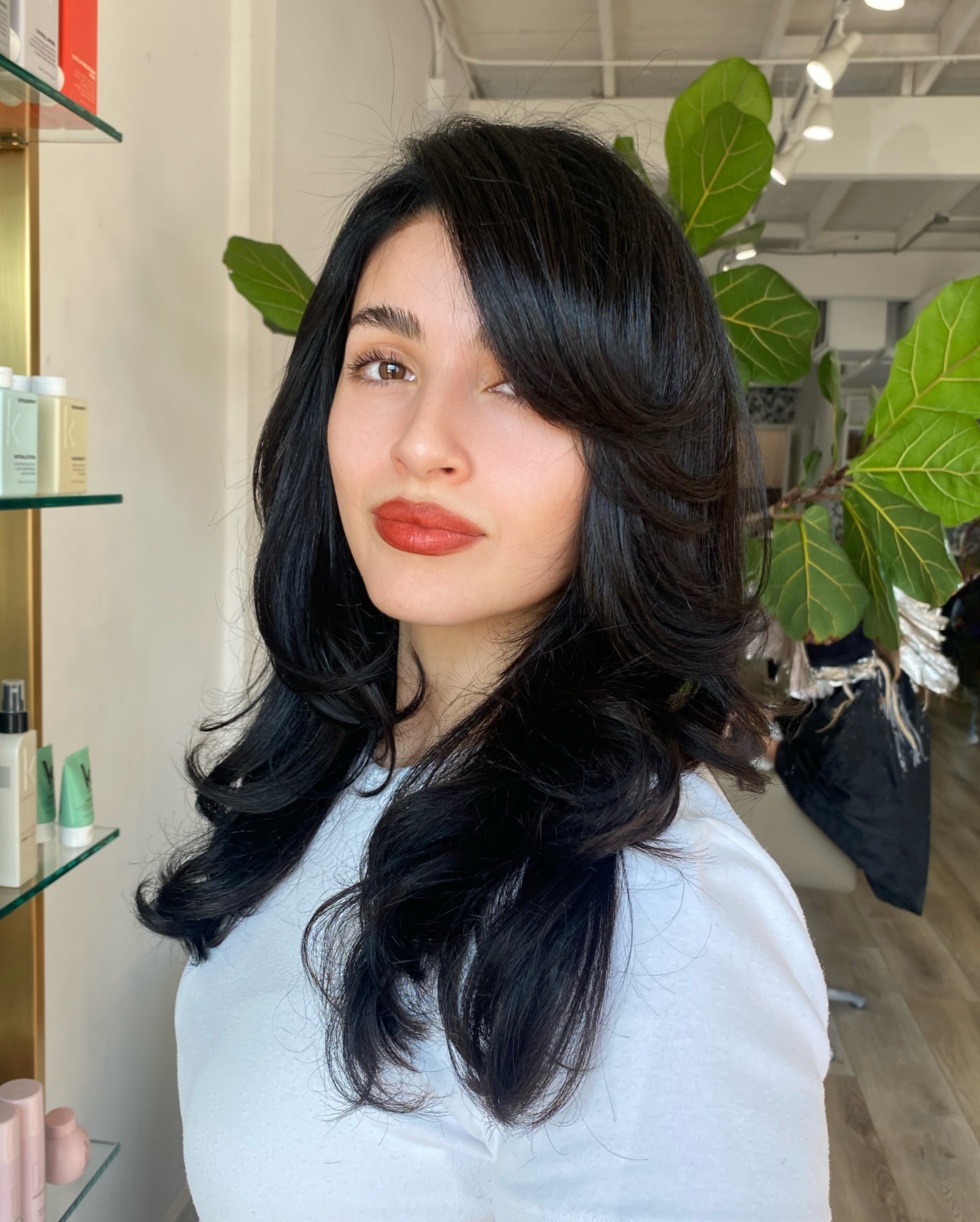 Voluminous Jet Black Layers With Side Swept Bangs