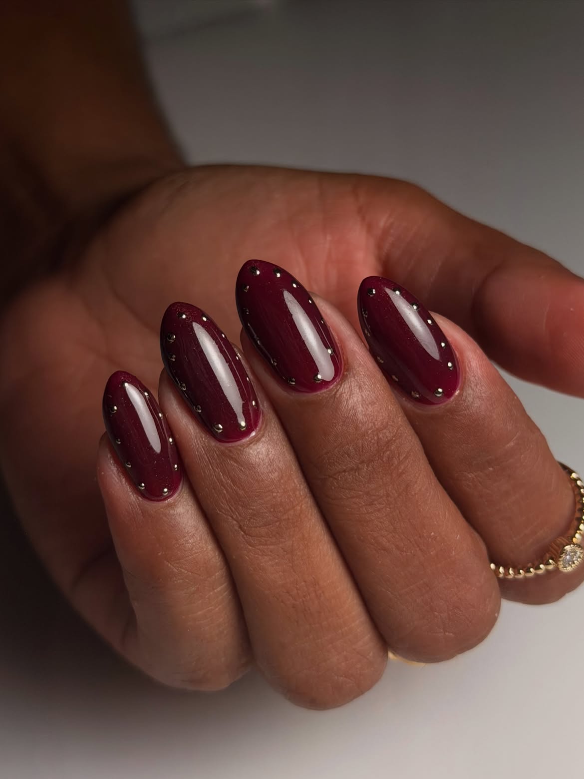 Glossy Burgundy Almond Nails With Silver Studs