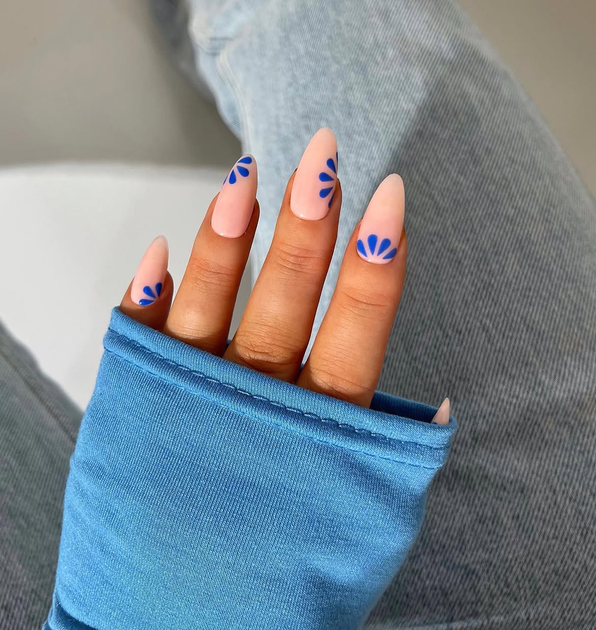 Glossy Nude Almond Nails with Blue Floral Accents
