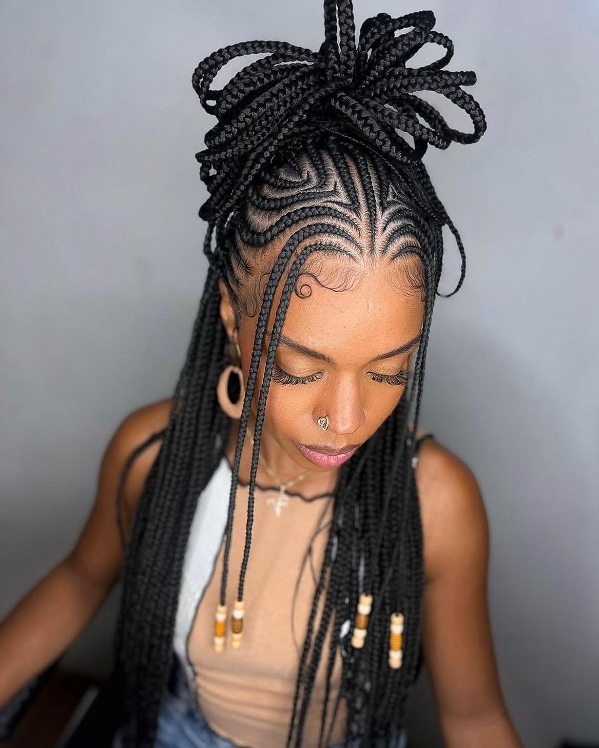 Intricate Cornrow Braids With High Bun And Loose Tendrils