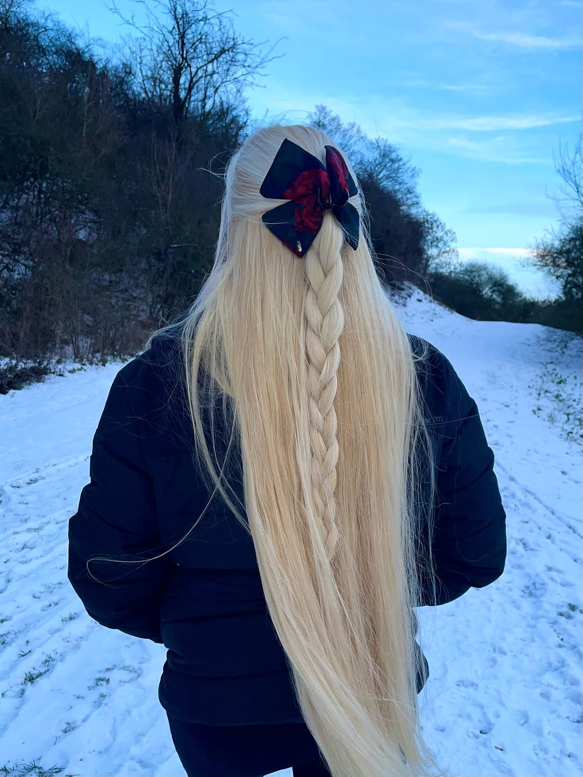 Long Platinum Blonde Half Up Braid With Dark Floral Bow