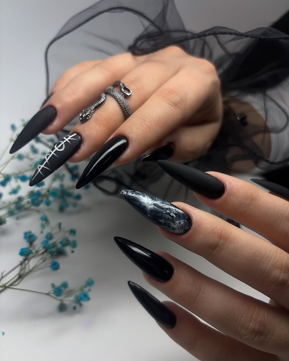 Matte Black Stiletto Nails with Marble Accent